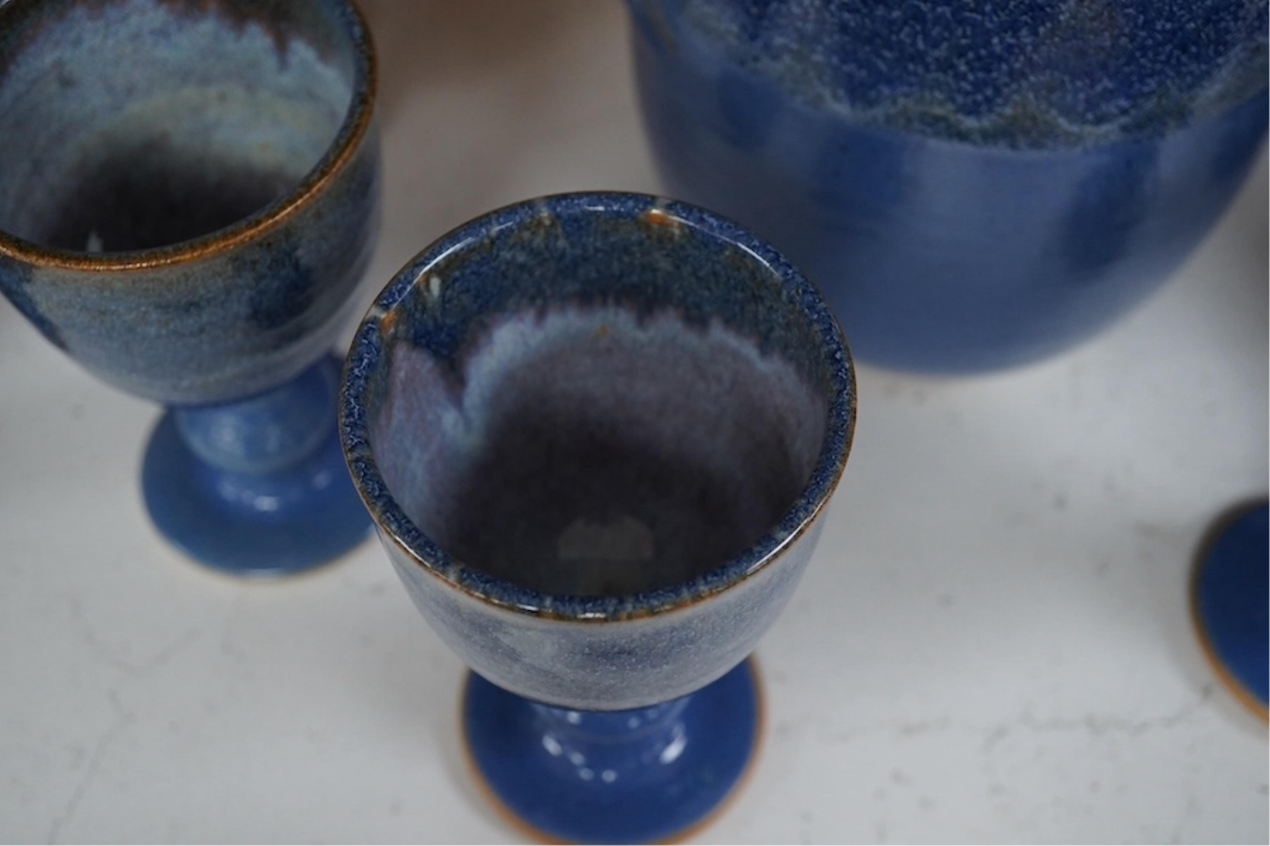 A Canterbury pottery, blue glaze jug and twelve goblets, jug 28cm high. Condition - fine chip to one goblet